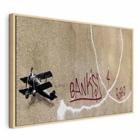Obraz - Samolot Banksy (1-częściowy) - graffiti czerwone napisy na tle muralu 60x40 W ramie drewnianej naturalnej